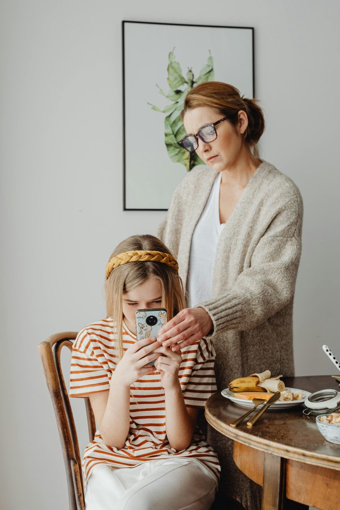 pexels-photo-6957250-6957250 A mother and daughter at breakfast with a smartphone, expressing modern family dynamics.