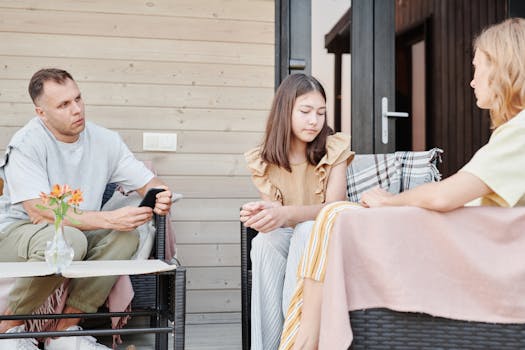 pexels-photo-8841578-8841578 A family of three having a serious conversation outdoors on a patio.